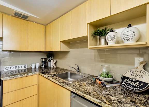 A kitchen with wooden cabinets and a granite countertop.