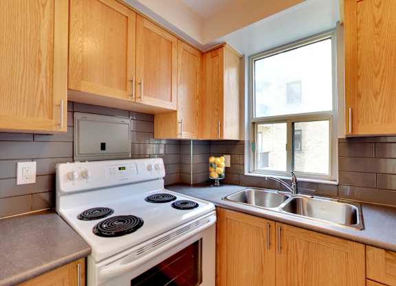 a kitchen with wood cabinets and white appliances and a window