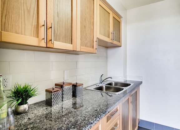 A kitchen with wooden cabinets and a granite countertop.