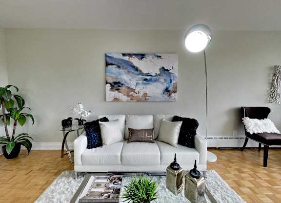 a living room with a white couch and a painting on the wall
