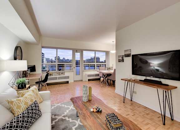 A modern living room with a white couch and a large flat screen TV.