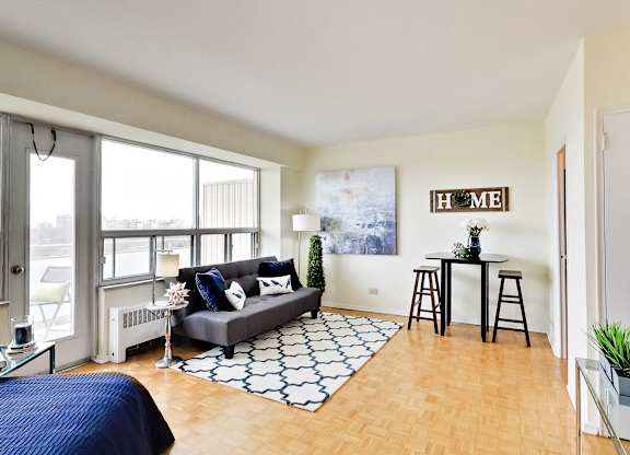 A living room with a couch, a rug, and a bar area.
