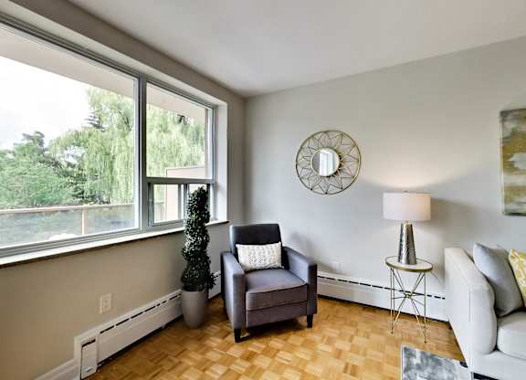 a living room with a couch and a chair and a large window