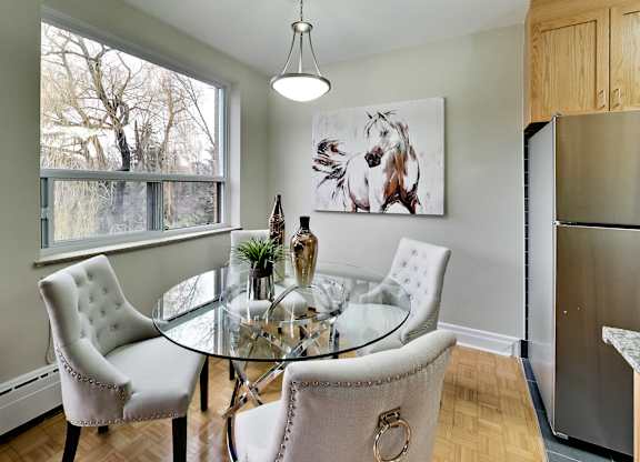 a dining room with a glass table and chairs and a refrigerator