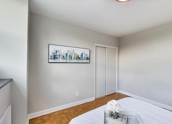 a bedroom with white walls and a white bed and a mirrored table