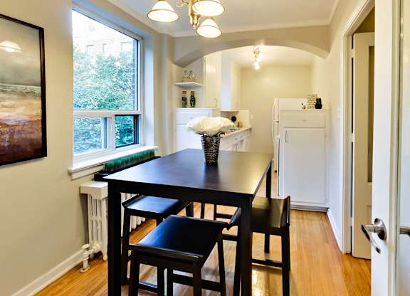a dining room with a black table and four black stools