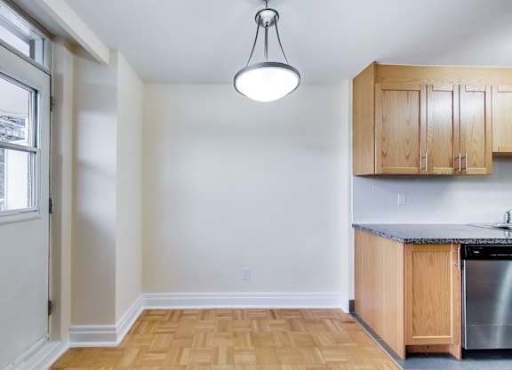 A kitchen with wooden cabinets and a stainless steel dishwasher.