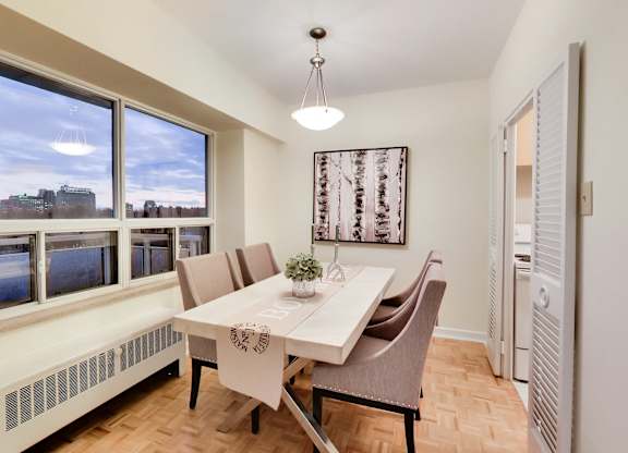 A dining room with a table set for two and a view of the city.