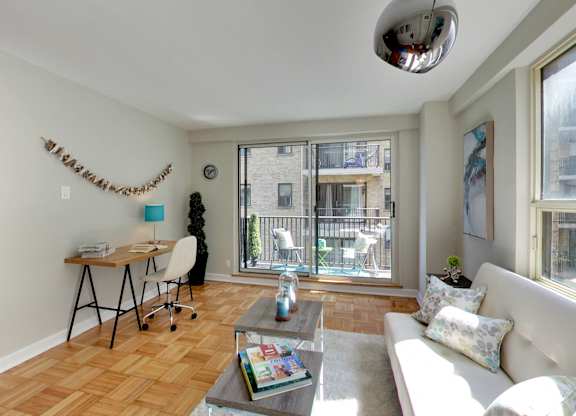 a living room with a couch and a desk and a large window