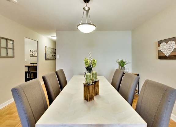 A long table with chairs and a vase of flowers on top.