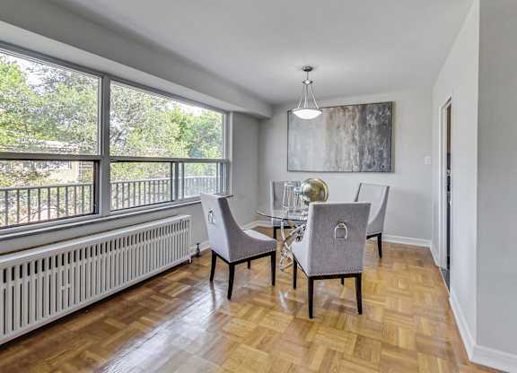 a dining room with a table and chairs and a large window
