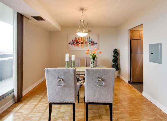 a dining room with a table and chairs and a refrigerator