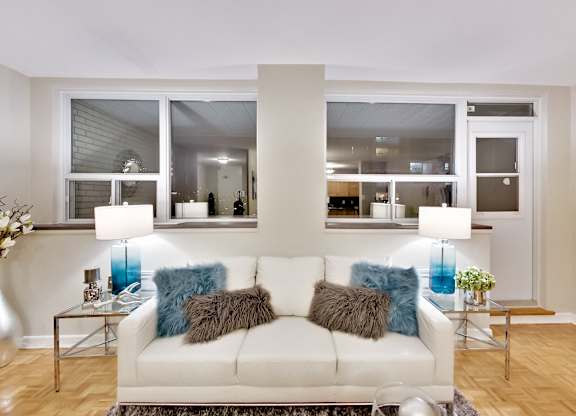 a living room with a white couch and pillows