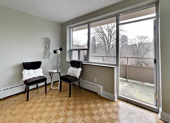 a living room with two chairs and a large window
