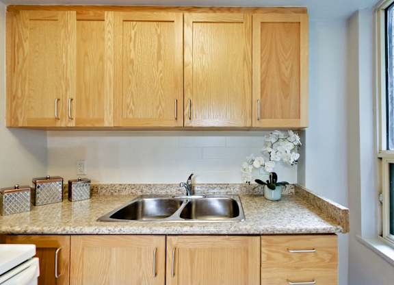 a kitchen with wooden cabinets and granite counter tops and a sink