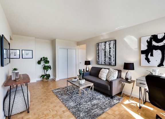 A living room with a couch, a chair, a coffee table, and a TV.