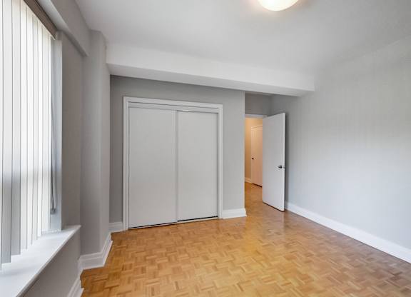 an empty living room with white walls and a wooden floor