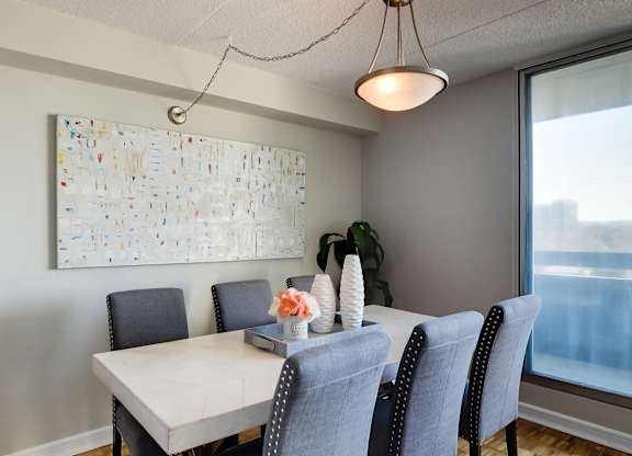 a dining room with a table and chairs and a painting on the wall