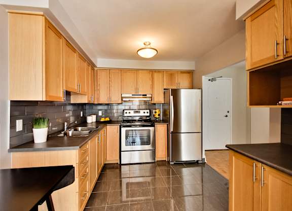 a large kitchen with wooden cabinets and stainless steel appliances