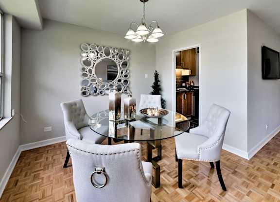 a dining room with a glass table and chairs
