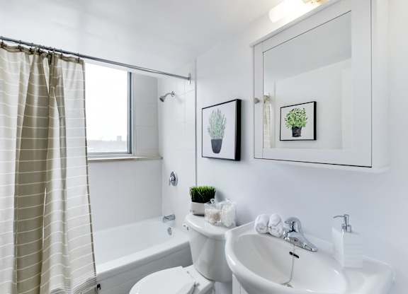 A white bathroom with a tub, toilet, and sink.