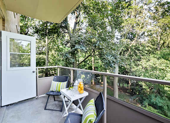 a patio with two chairs and a table on a balcony