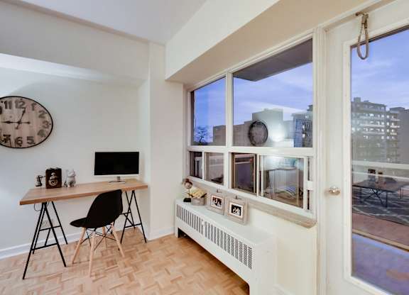 A room with a desk and a chair in front of a window.