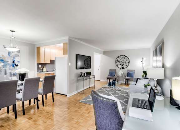 a living room and dining room with a table with a laptop on it