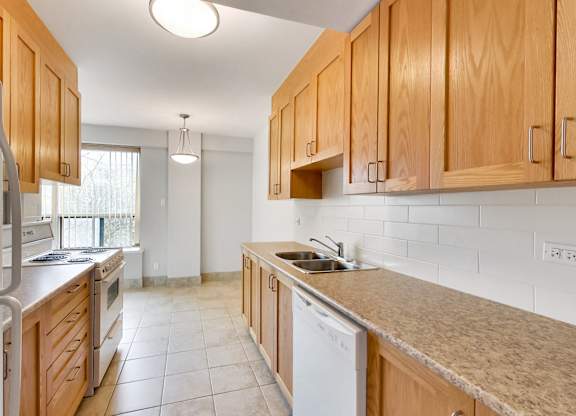 an empty kitchen with wooden cabinets and a counter top