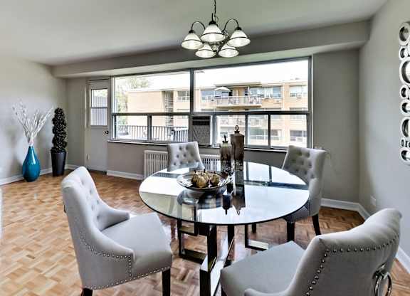 a dining room with a table and chairs and a large window