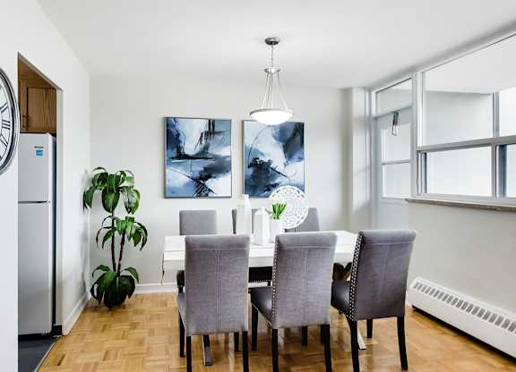 a dining room with a table and chairs and a large window