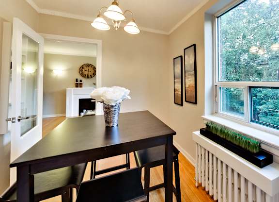 a dining room with a table and chairs and a large window