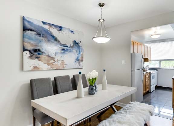 an image of a dining room with a white table and chairs