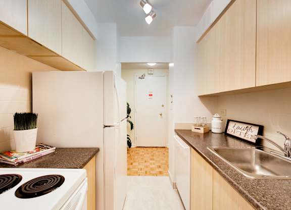 A kitchen with a white stove top oven and a white refrigerator.