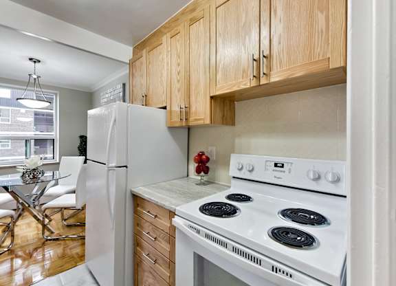 a kitchen with a white stove and refrigerator and wooden cabinets