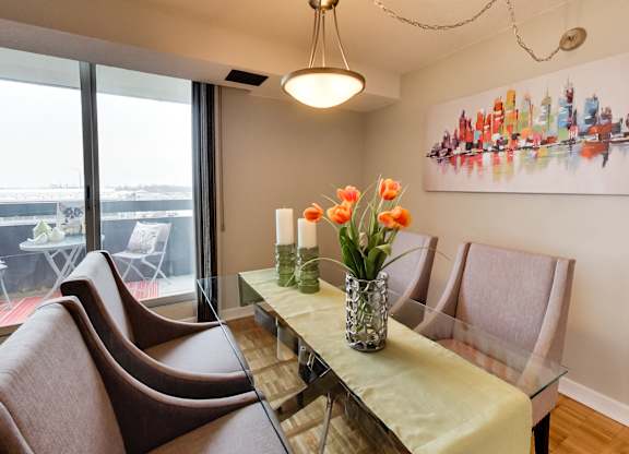 a dining room with a glass table and chairs and a large window