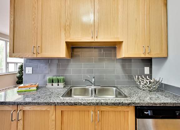 a kitchen with wooden cabinets and granite counter top and a sink