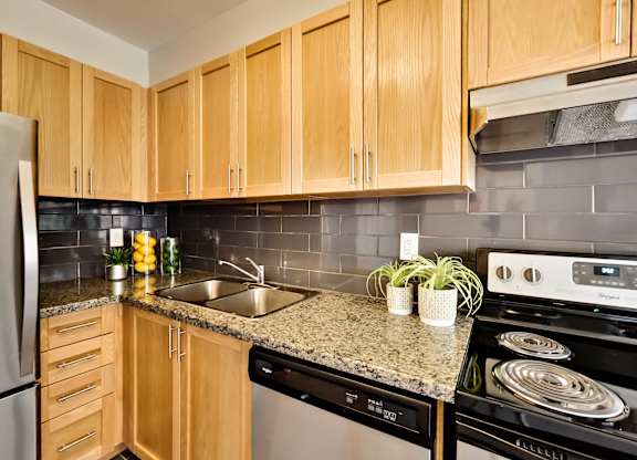 a kitchen with wooden cabinets and granite counter top and black appliances