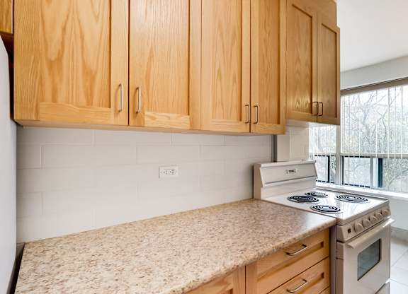 an empty kitchen with wooden cabinets and a stove top oven