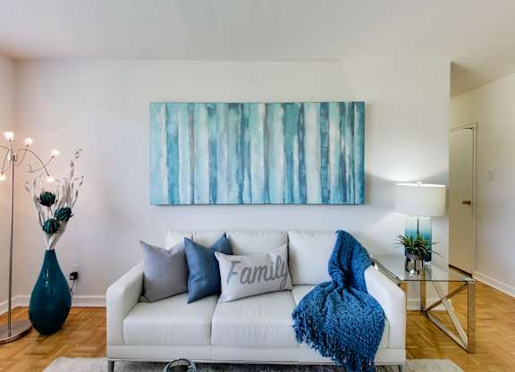 a living room with a couch and a painting on the wall