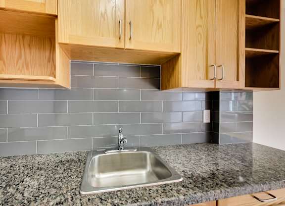 a stainless steel sink in a kitchen with granite counter tops
