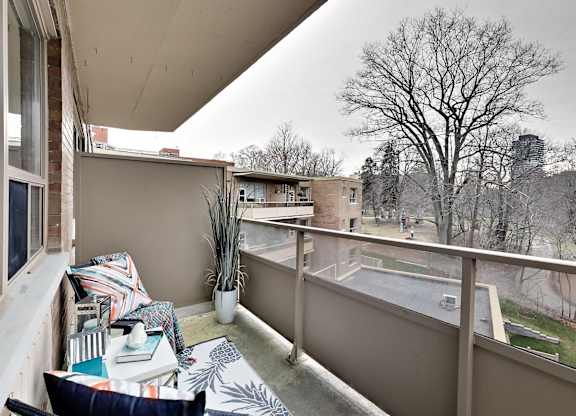 a balcony with a couch and a view of a pool and a tree