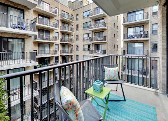 a balcony with two chairs and a table on a balcony