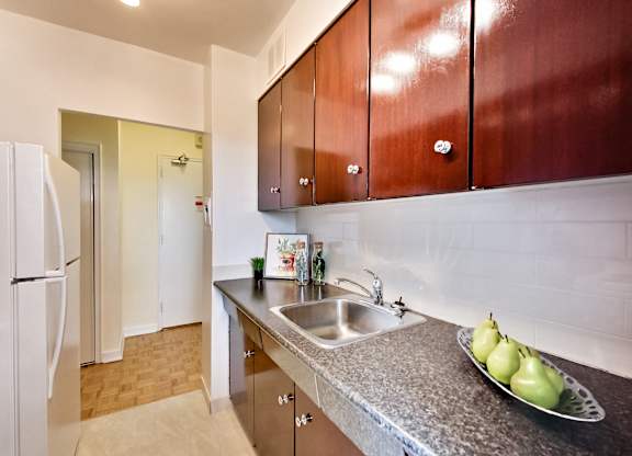 A kitchen with brown cabinets and a white refrigerator.