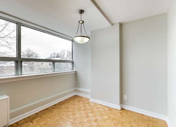 an empty living room with a large window and wood flooring