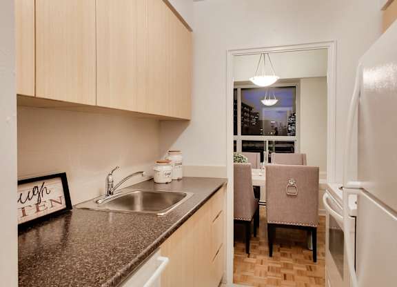 A kitchen with a sink, a fridge, and a window.