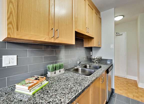 a kitchen with wood cabinets and granite counter top and a sink