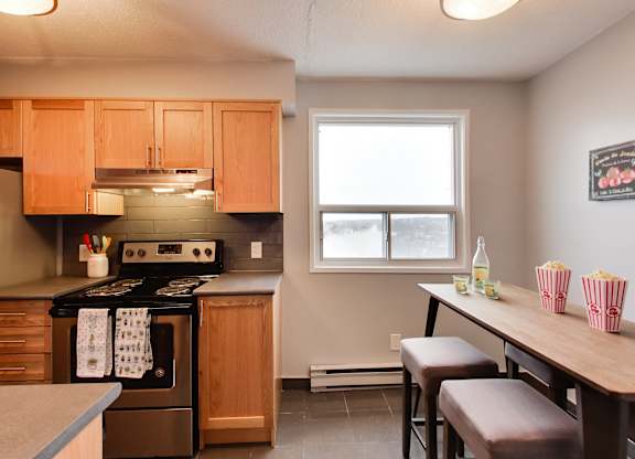 a kitchen with wooden cabinets and a table with chairs