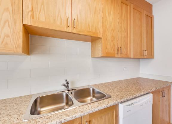 an empty kitchen with wooden cabinets and a sink