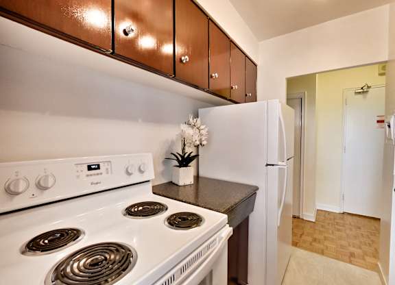 A white stove and oven in a kitchen with brown cabinets.